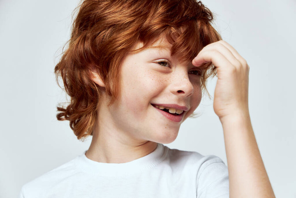 Yüzünün yanında el ele tutuşan neşeli kızıl çocuk gülüşü kırpılmış beyaz tişört.  - Fotoğraf, Görsel