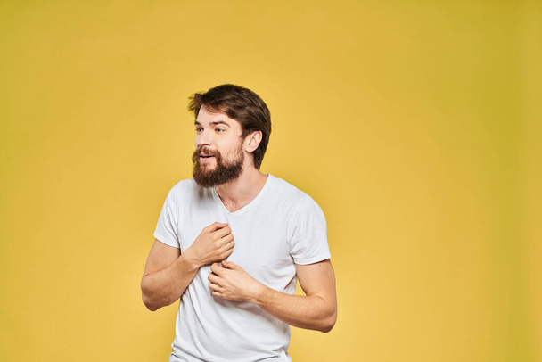 Bearded man in white t-shirt emotions close-up fun yellow background - Fotoğraf, Görsel