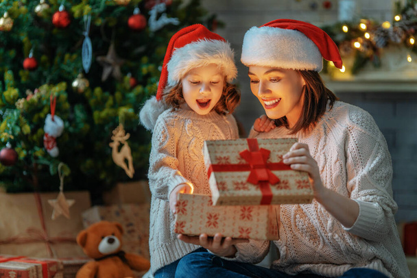 Merry Christmas and Happy Holiday! Loving family mother and child with magic gift box. - Foto, Imagen