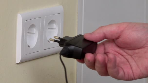 man hand put two phone charger into power socket. 4K - Footage, Video