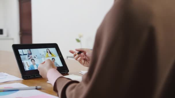 Asijské muslimka pomocí digitální tablet mluvit s kolegou o plánu videohovory brainstorm on-line setkání, zatímco vzdáleně pracovat z domova v obývacím pokoji. Sociální distancování, karanténa pro virus korony. - Záběry, video