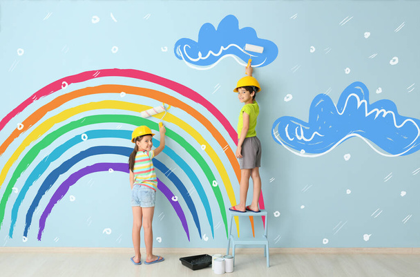 壁にカラフルな虹と雲を描く子供たち  - 写真・画像