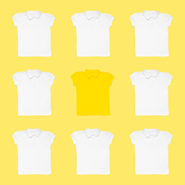 T-shirt gialla tra quelle bianche su sfondo a colori. Concetto di unicità - Foto, immagini