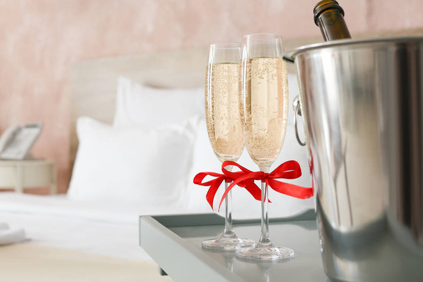 Окуляри шампанського та льодового відра на столі в готельному номері
 - Фото, зображення