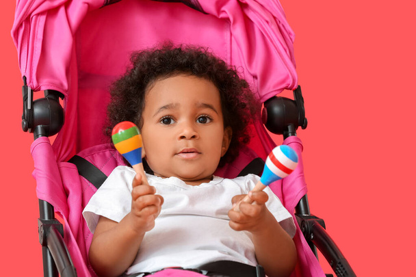 Aranyos afro-amerikai baba babakocsi színes háttér - Fotó, kép