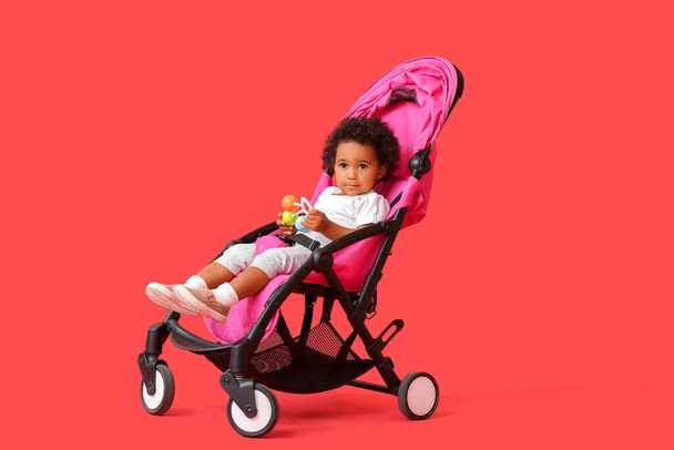 かわいいアフリカ系アメリカ人の赤ちゃんでベビーカーの色の背景 - 写真・画像