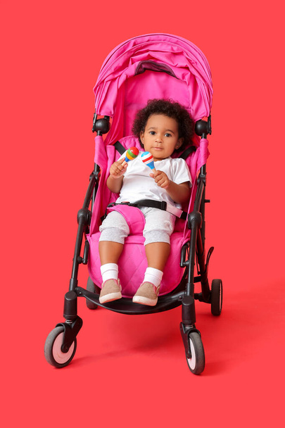 Cute African-American baby in stroller on color background - Φωτογραφία, εικόνα