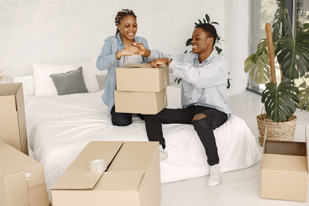 Couple with boxes moving into new home smiling - Photo, image