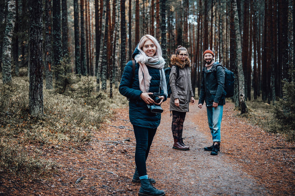 Joyful students pose on path in autumn forest and look at camera - Foto, Bild