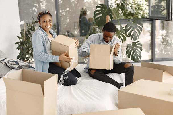 Couple with boxes moving into new home smiling - 写真・画像