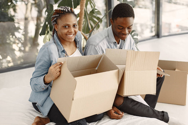 Couple with boxes moving into new home smiling - Foto, Bild