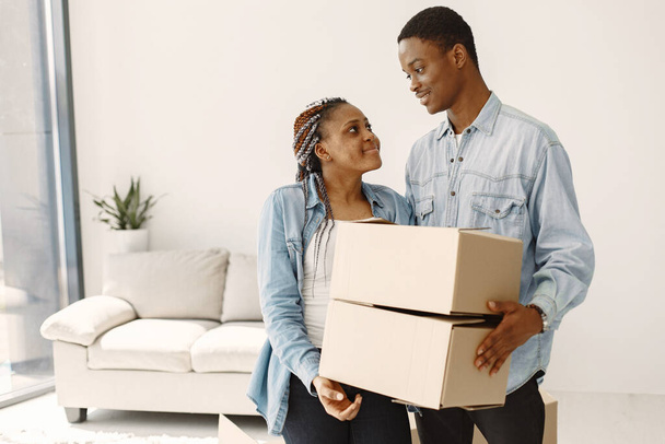Paar mit Kisten zieht lächelnd in neues Zuhause ein - Foto, Bild