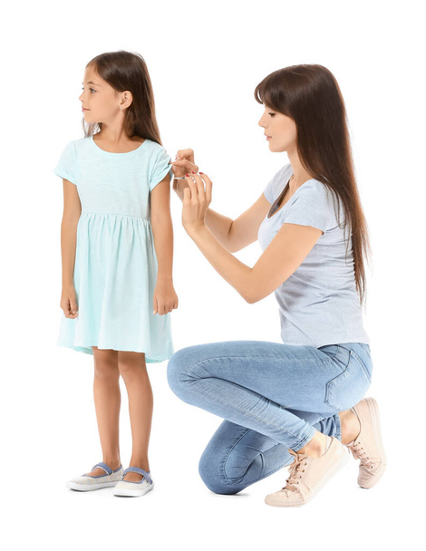 Mother giving her diabetic daughter insulin injection on white background - Photo, image