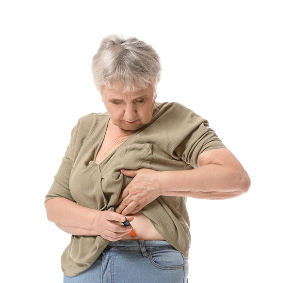 Mulher diabética sênior que se administra injeção de insulina em fundo branco - Foto, Imagem