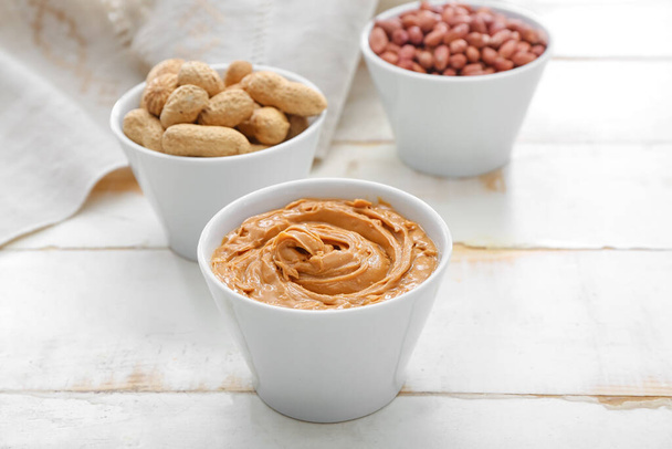 Миски зі смачними арахісом та маслом на столі
 - Фото, зображення