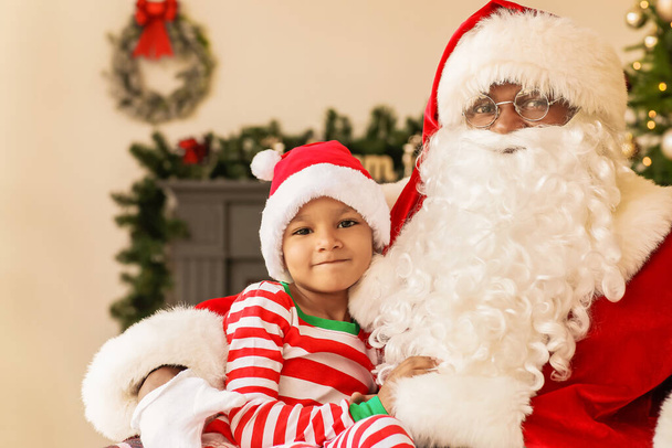 Afro-americano Babbo Natale con ragazzo carino a casa la vigilia di Natale - Foto, immagini