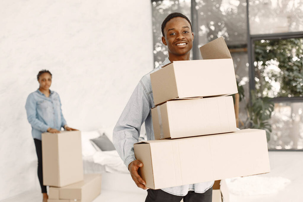 Couple with boxes moving into new home smiling - Foto, immagini