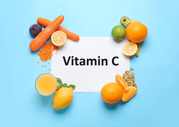 Paper sheet with text VITAMIN C and fresh products on color background - Foto, Imagen