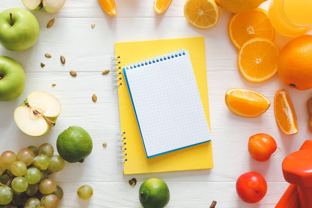 Fresh products with notebooks on white wooden background. Diet concept - Photo, Image