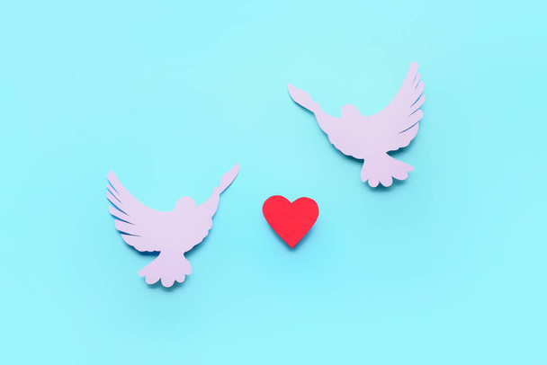 χάρτινα περιστέρια και καρδιά σε έγχρωμο φόντο. Διεθνής Ημέρα Ειρήνης - Φωτογραφία, εικόνα