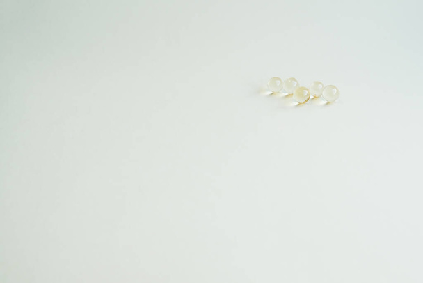 geneeskrachtige capsules met vitaminen, gele kleine ronde capsules - Foto, afbeelding