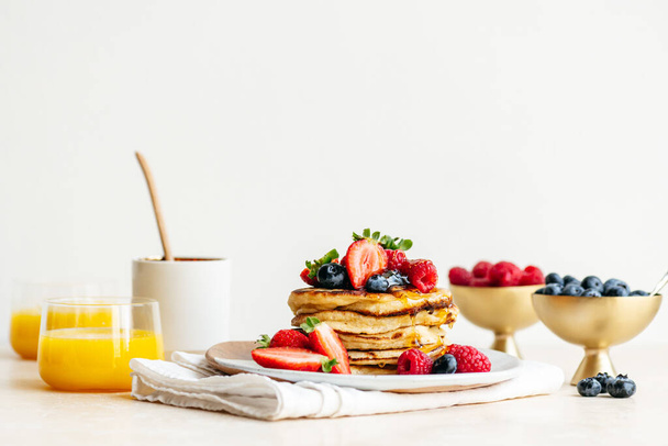 A stack of sourdough pancakes with berries and orange juice - Foto, immagini
