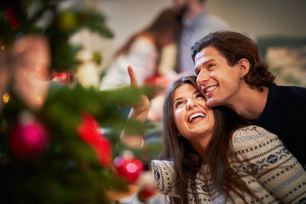 Adult couples having fun over Christmas tree - Фото, зображення