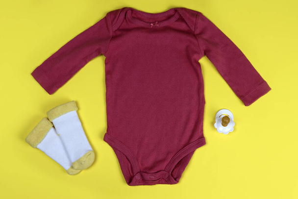 Newborn baby clothing bodysuits and socks on a bright background - Valokuva, kuva