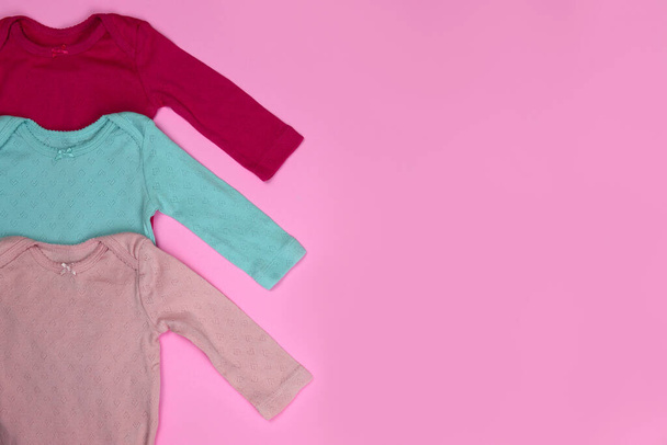 Costumes et chaussettes pour bébés nouveau-nés sur fond rose - Photo, image