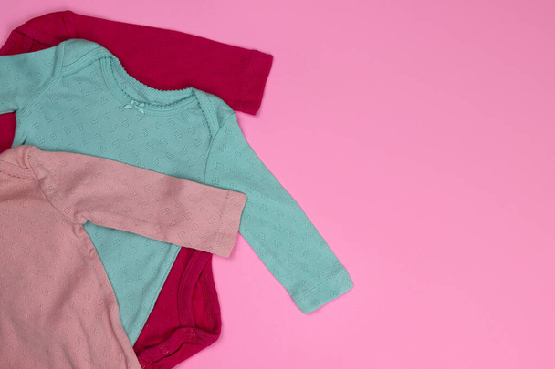 Neugeborene Babybekleidung Bodys und Socken auf rosa Hintergrund - Foto, Bild