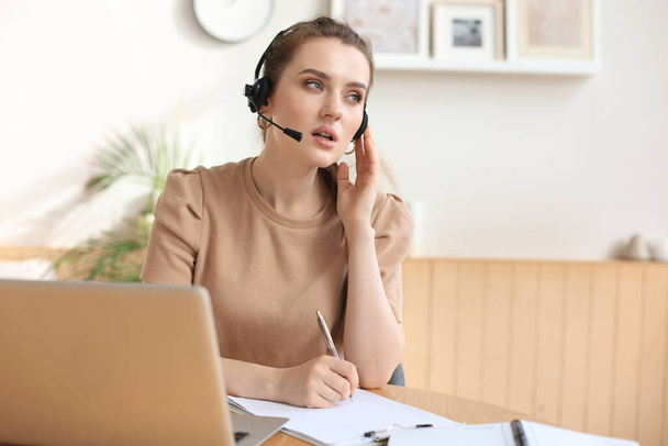 Freelance operator talking with headsets and consulting clients from home office - Fotografie, Obrázek
