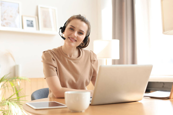 Freelance operator talking with headsets and consulting clients from home office - Foto, imagen