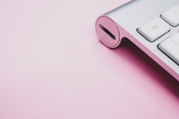 Egy modern és tiszta billentyűzet közelsége rózsaszín felületen - Fotó, kép