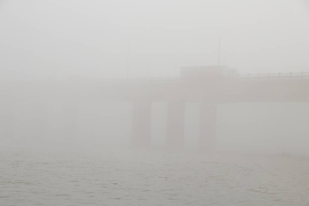 Старий міст у тумані в україні в місті Дніпро вранці. - Фото, зображення