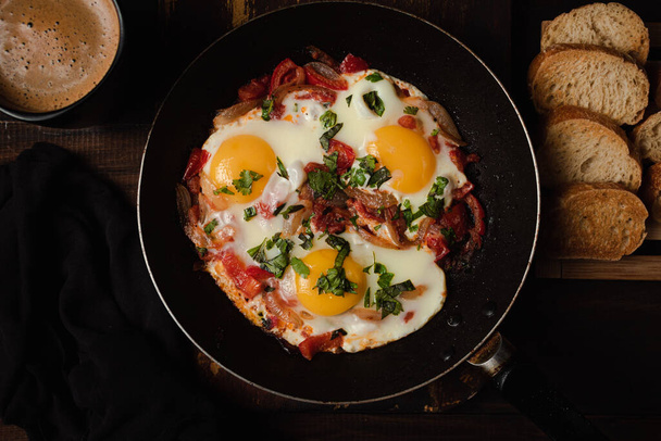 A high angle shot of delicious eggs and bacon on the pan - Фото, изображение