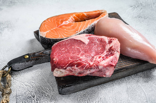 Set of raw meat steaks salmon, beef and chicken. White background. Top view. - Φωτογραφία, εικόνα