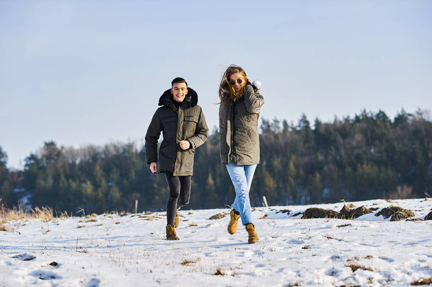 happy couple hugging and laughing outdoors in winter - Foto, immagini
