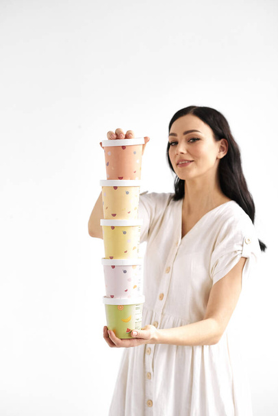 Girl holding a tower of colored paper box. Disposable eco tableware concept - Fotografie, Obrázek