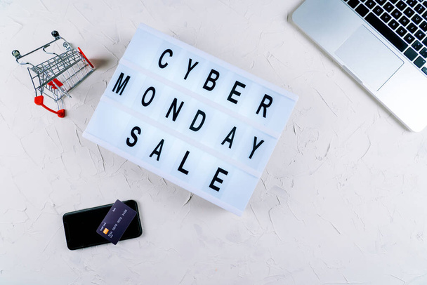 Top view of laptop, cyber monday promotion sale words on lightbox, gift boxes, laptop , shopping cart and bag, credit bank card on table. Online shopping, Sale, e-shopping, ordering, payment.concept. - Fotó, kép