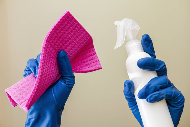 A human hands in protective gloves hold spray disinfectant and cleaning cloth - Photo, Image