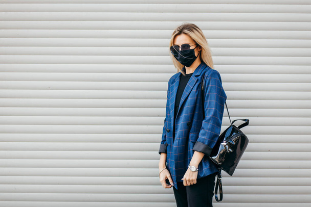 Nuori komea muoti nainen reppu kasvoissa saastuminen naamio suojella itseään koronavirus kävely kaupungissa  - Valokuva, kuva