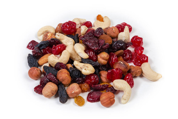 Kleine stapel van mix van verschillende noten, gedroogd fruit en bessen op een witte achtergrond - Foto, afbeelding
