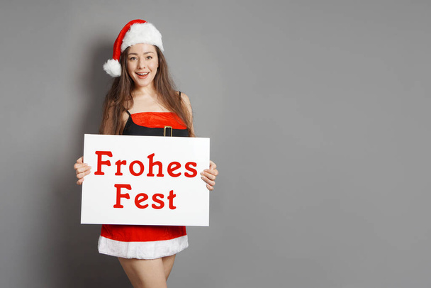 Frohes Fest - female santa wishes happy holidays in German - Zdjęcie, obraz