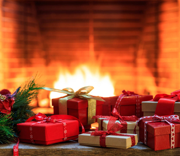 Cheminée en feu, cadeaux de Noël. Confortable maison chaude, coffrets cadeaux de Noël, feu de bois rondins lumineux dans l'obscurité. - Photo, image