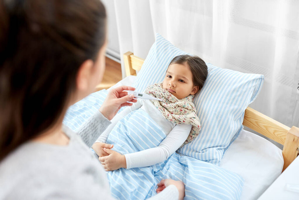 mother measuring temperature of sick daughter - Photo, image