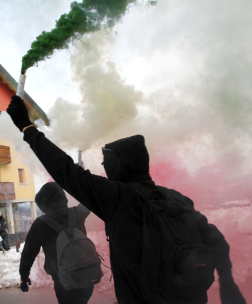 Demonstranten in schwarzen Gewändern mit grünem Rauch - Foto, Bild