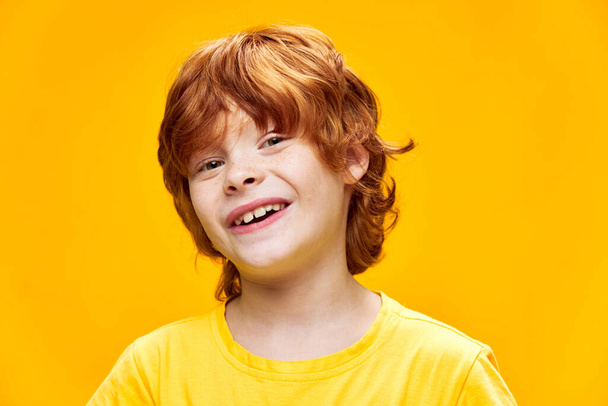 Leuke roodharige jongen glimlach close-up geel  - Foto, afbeelding