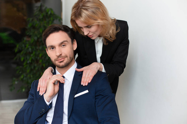 Female office worker seduces to male boss. Young woman stroking male shoulders. Women empowerment concept. Feminism concept. Copy space - Fotoğraf, Görsel