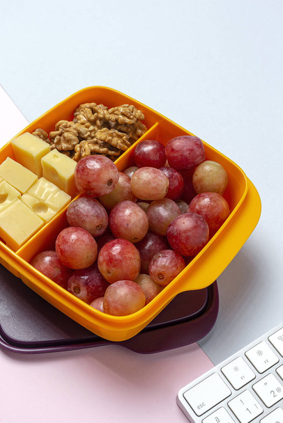 Healthy Food in Plastic containers ready to eat with Cheese, grapes and walnuts on the work table. To take away.walnuts - Photo, image