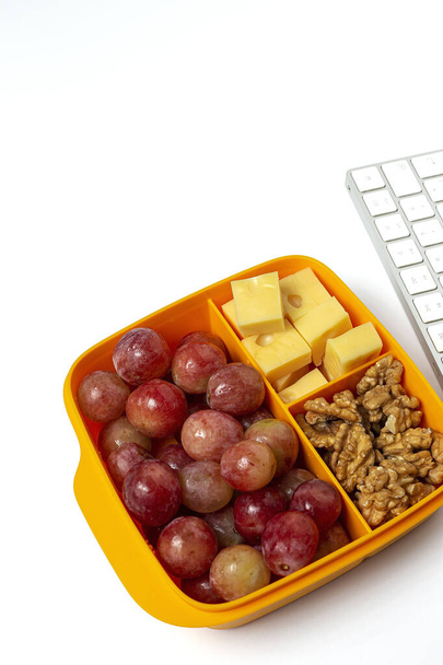 Healthy Food in Plastic containers ready to eat with Cheese, grapes and walnuts on the work table. To take away.walnuts. Isolated - Photo, Image